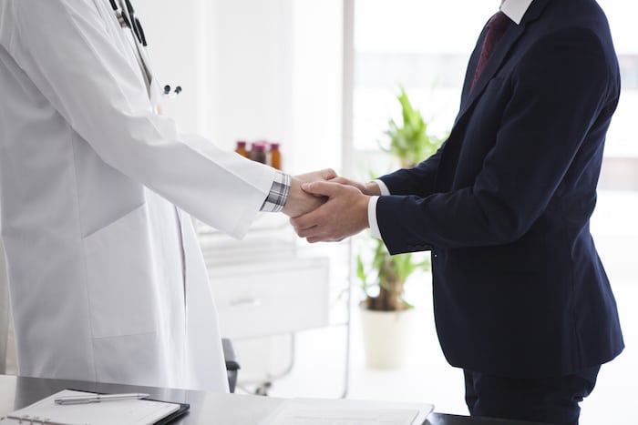 Doctor and businessman are shaking hands