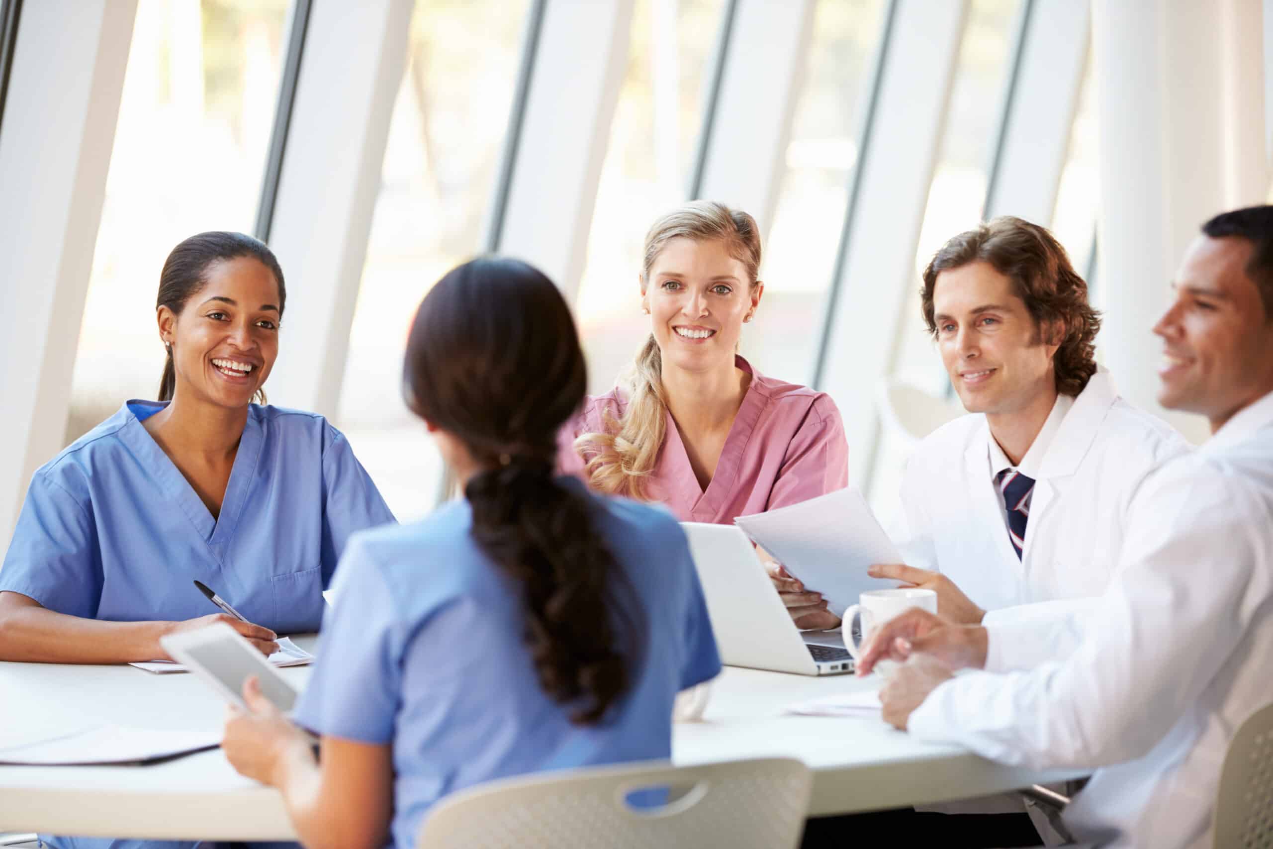 Medical Team Meeting Around Table In Modern Hospital