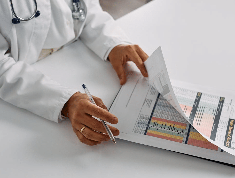 doctor with pen, reviewing data on clip board